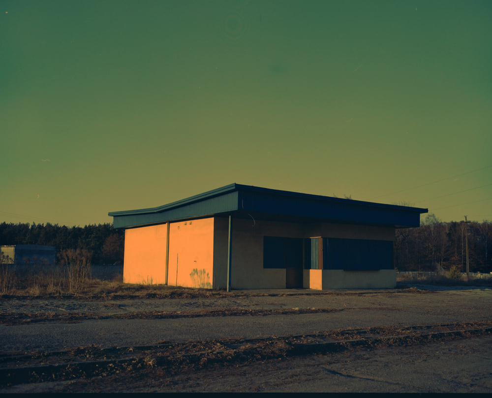 The frame after a complement inversion: the road is neutral but the sky has gone green and the pale wall has gone pink